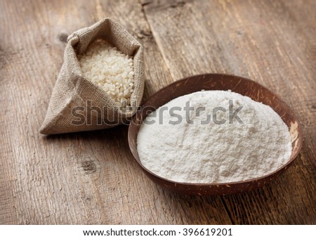 rice flour in a wooden bowl, rice on the old wooden background. gluten-free Royalty-Free Stock Photo #396619201