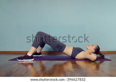 Young woman in sportswear doing sport at home