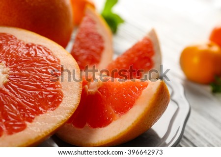 Pieces of grapefruit on wooden light background