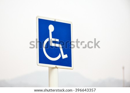 Standard handicapped people access sign with hazy sky in the background