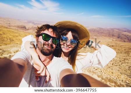 Close up self portrait , happy  hipster  couple  traveling , Handsome man with beard and young pretty cheerful girl making selfie . Jordan desert .Hikers enjoying  amazing view. 