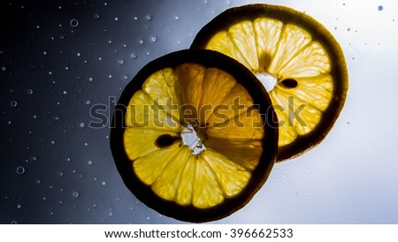 isolated sliced lemon with one flash below it and graduated to black