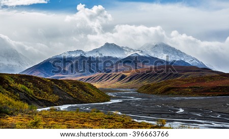 The braided channels of the Toklat river meanders through colorful Autumn foliage in Denali National Park, Alaska. Royalty-Free Stock Photo #396663766