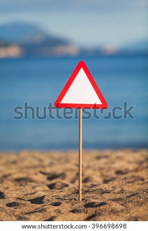 A road sign installed on a sandy beach