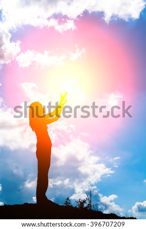 Silhouette of woman praying over beautiful sunrise background
