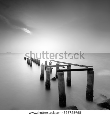Abandoned jetty with fine art retouching black and white. Focus on the jetty piers. Royalty-Free Stock Photo #396728968