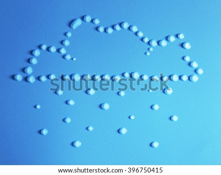 Rain cloud made of water drops on blue background