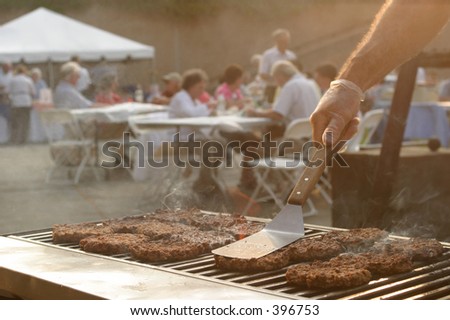 Grilling burgers at a summer event.