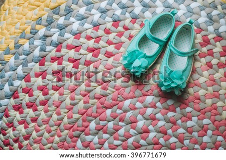Kids' sandals on the handmade colorful rug from a variety of different plaited braids