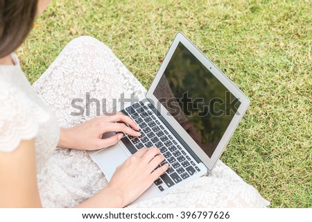 Woman work with computer on grass floor in park