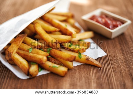 french fries in paper bag and red sauce. selective focus Royalty-Free Stock Photo #396834889