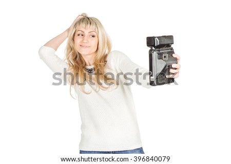 portrait of young woman taking selfie on retro camera.  isolated on white background. vintage and lifestyle concept