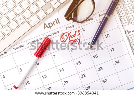 April 1 in the business calendar. Written on the calendar April Fools' Day. April fool day on first day of april month. Concept - calendar, table, pen, keyboard, work, glasses.