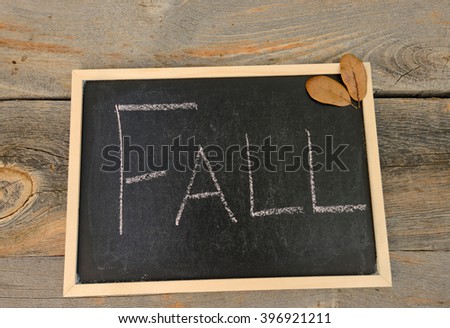 fall written in chalk on a chalkboard on a rustic background