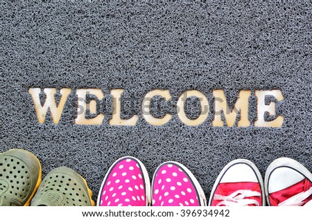 Welcome carpet with foot-ware on it Royalty-Free Stock Photo #396934942