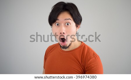 Surprised Asian man in red t-shirt.