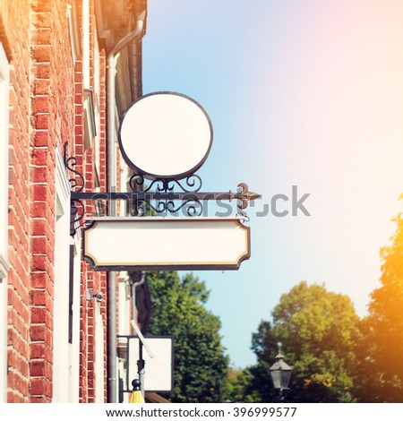 Blank round white signboard with arrow on the wall of old brick building, mockup