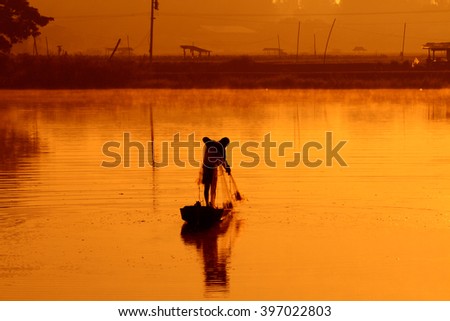 Silhouette fishermen fishing in the pond, Thailand