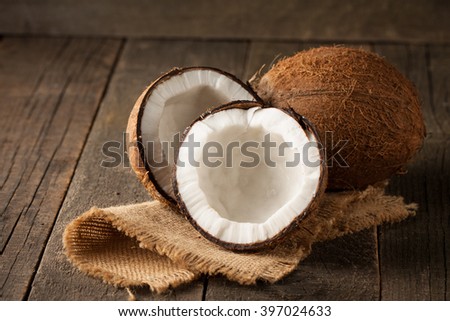 Ripe half cut coconut on a wooden background. Ripe half cut coconut with milk on a wooden background