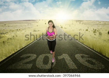 Picture of Asian female runner workout on the road with number 2016 on the asphalt