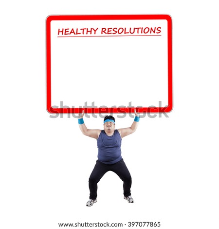 Picture of overweight man lifting a board of healthy resolutions with copy space, shot in studio