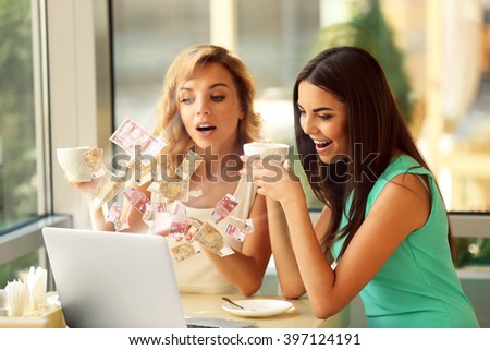 Financial concept. Make money on the Internet. Beautiful young women with laptop in cafe