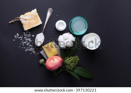 Spa products with flowers on black background