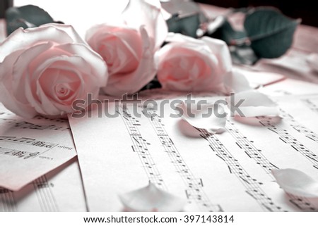 Beautiful roses on music notes background