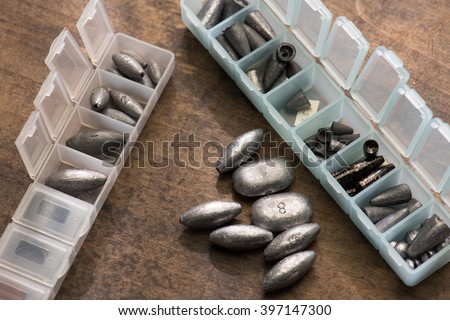 Lead weights or sinkers used for fishing, in variety of sizes, in a plastic separated compartment case. Royalty-Free Stock Photo #397147300