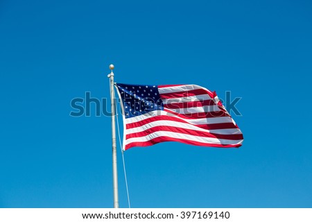 American flag waving in the wind on a blue sky