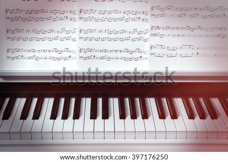 Piano keyboard and musical notes close up