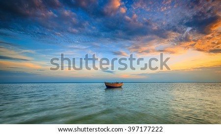Lonely boat on the Baltic Sea at sunset. HDR - high dynamic range Royalty-Free Stock Photo #397177222