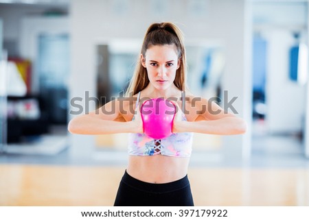 Sporty brunette woman with pigtail training at gym with a ball