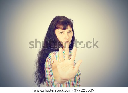 Young Caucasian woman showing stop hand.On gray background.
