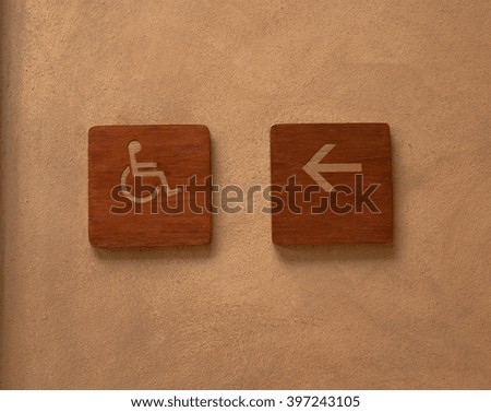 wooden of disabled signs on orange cement background
