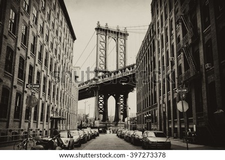 Manhattan bridge seen from a brick buildings in Brooklyn street in perspective, New York, USA. Business and travel background. Vintage, retro postcard with sepia filter.
