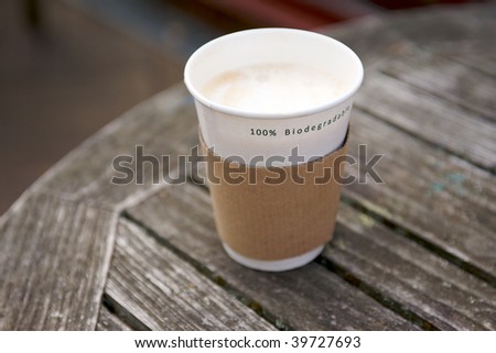 A Biodegradable Disposable Cup containing a hot drink on a wooden table surface in shallow DOF Royalty-Free Stock Photo #39727693