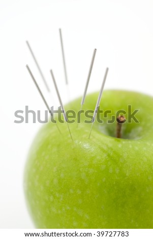 A green apple used to demonstrate the use of Acupuncture needless Royalty-Free Stock Photo #39727783