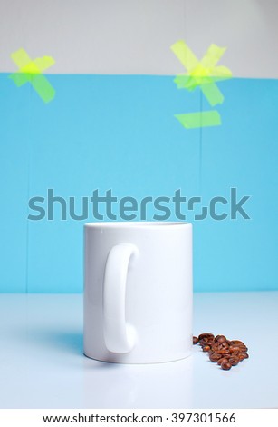 cup of coffee on the table with beans 
on a blue background