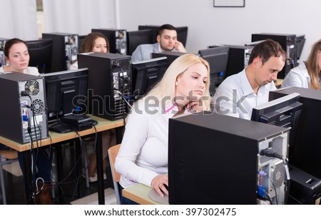 unhappy staff sitting at desks and looking at PC screens