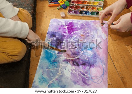 Boy learns to paint with watercolors