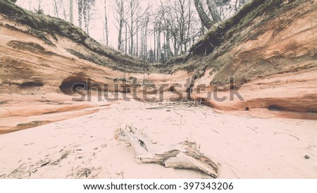 sandstone cliffs by the river in Gauja national park in latvia - vintage film effect