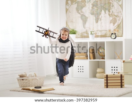 concept of dreams and travels. happy child playing with an airplane pilot and runs the room Royalty-Free Stock Photo #397382959