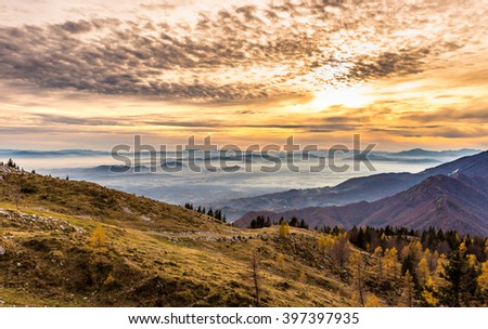 Sunset in the mountains. View of the valley. Golden hour yellow dusk or dawn with sun sunset or sunrise. Europe - Slovenia.