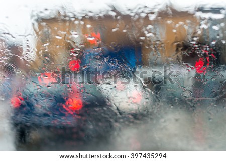 Blurred picture of traffic through a car windscreen during heavy rain.