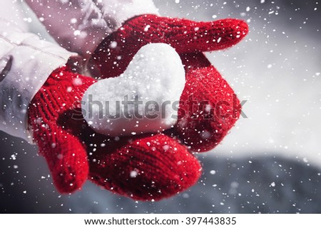 Heart of snow. Modeling. It lies on the palms on the gloves. Royalty-Free Stock Photo #397443835