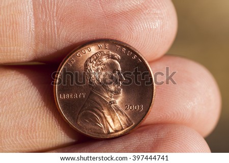   photographed close-up of one US cent in the hands of a man,