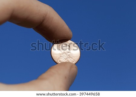  photographed close-up of one US cent in the hands of a man,