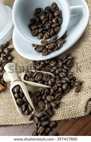 cup of coffee whit coffee beans on jute on wooden background