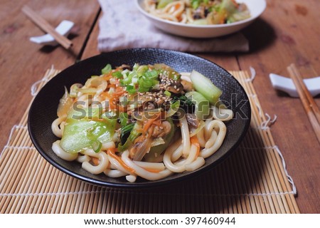 Healthy Japanese dish; Vegetarian Udon Yaki. Udon stir fried with Bok choy, carrot, onion and champignons in garlic, ginger and soy sauce. Royalty-Free Stock Photo #397460944